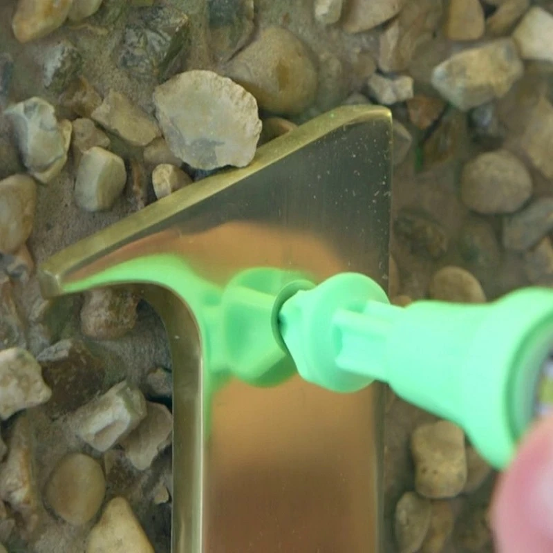 Marxman green marking tool used to position a metal house number on stone