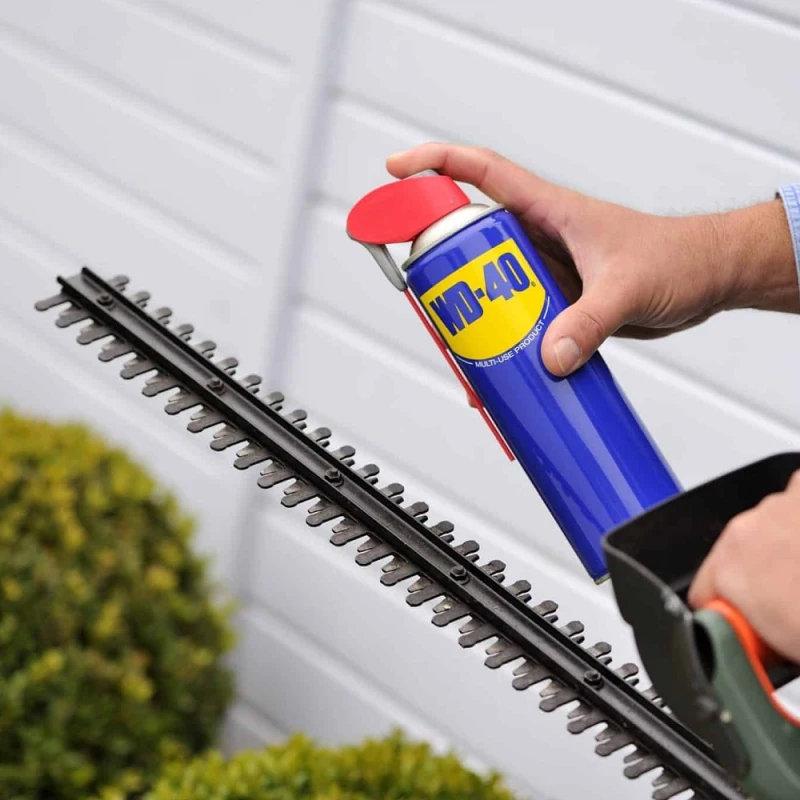 WD-40 spray applied to hedge trimmer blades to clean and protect metal surface