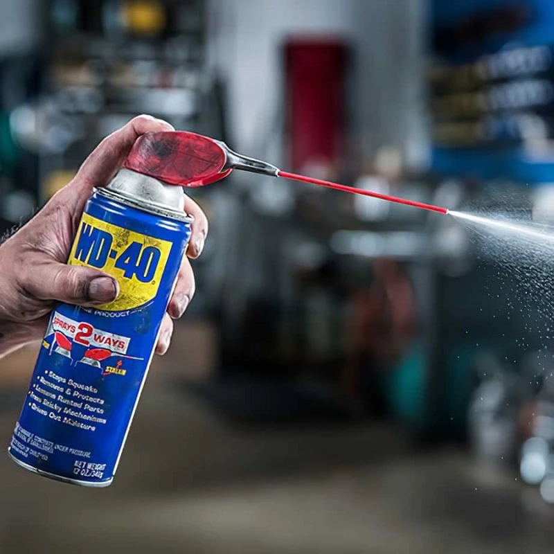 Person using WD40 Multi-Use Maintenance Aerosol Smart Straw with spray action.