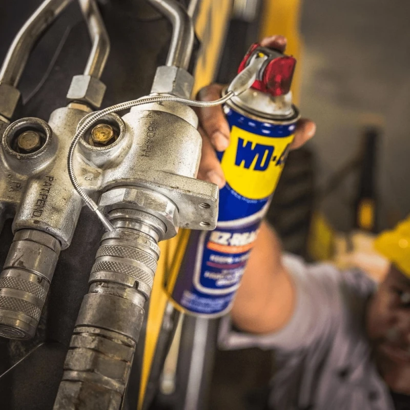 Person using WD40 Multi-Use Smart Flexible Straw Maintenance Aerosol on machinery.
