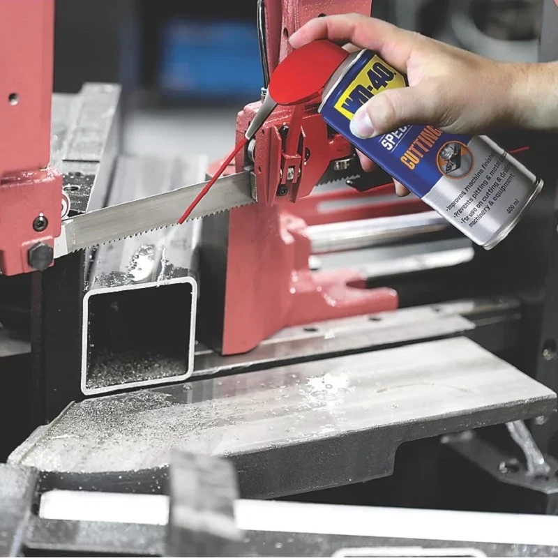 A person using WD40 Specialist Multi-Purpose Cutting Oil Spray on a metal cutting saw.