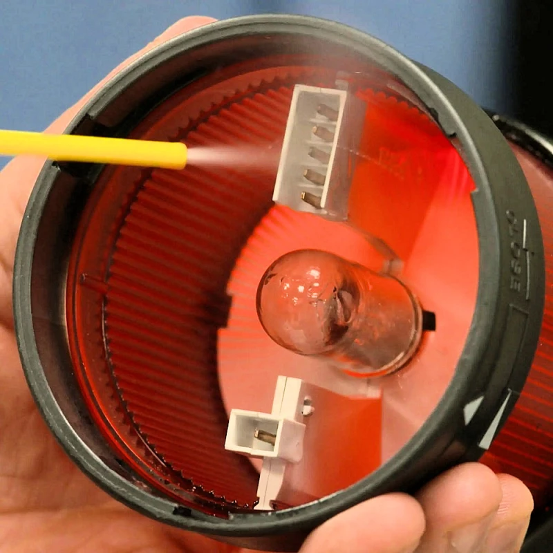 Close-up of a hand using WD40 Specialist Fast Drying Electrical Contact Cleaner on an electrical component.