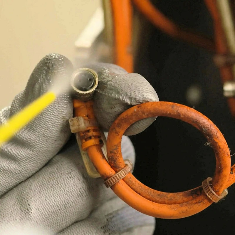 Person using WD40 Specialist Fast Drying Electrical Contact Cleaner on an orange cable connection.