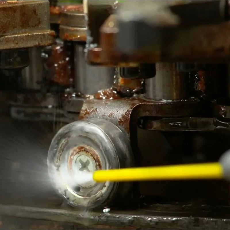 Close-up of a yellow spray nozzle applying degreaser to a rusty metal component.