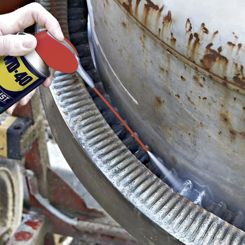 Hand applying WD40 Specialist Spray White Lithium Grease Lubricant to a large metal gear.
