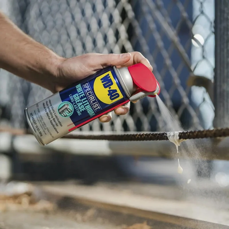 Person applying WD40 Specialist Spray White Lithium Grease Lubricant to a metal chain.