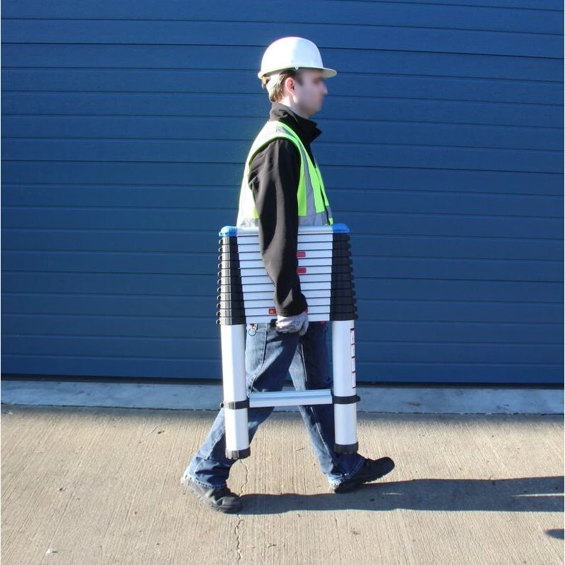 Person carrying a folded telescopic ladder while wearing a safety helmet and vest.