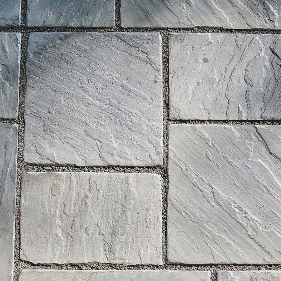 Close-up of textured grey stone slabs with light-coloured jointing compound, showing a clean rectangular layout