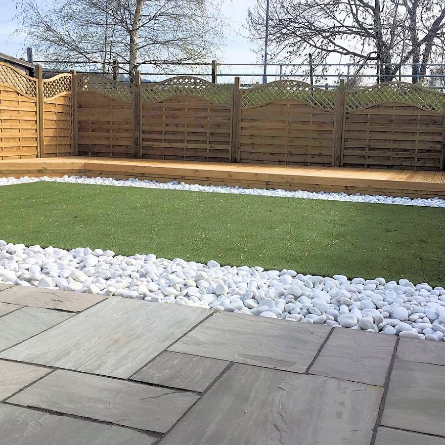 Garden layout with grey paving, white stones and synthetic grass