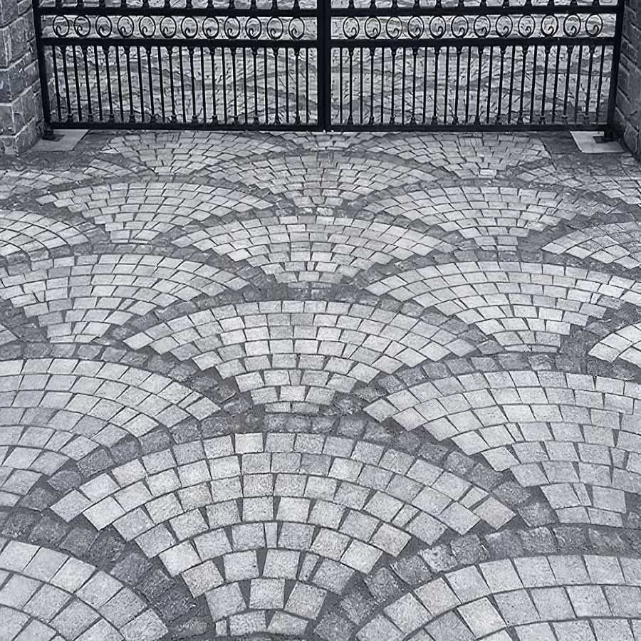 Stone driveway with detailed arch pattern and gate entrance