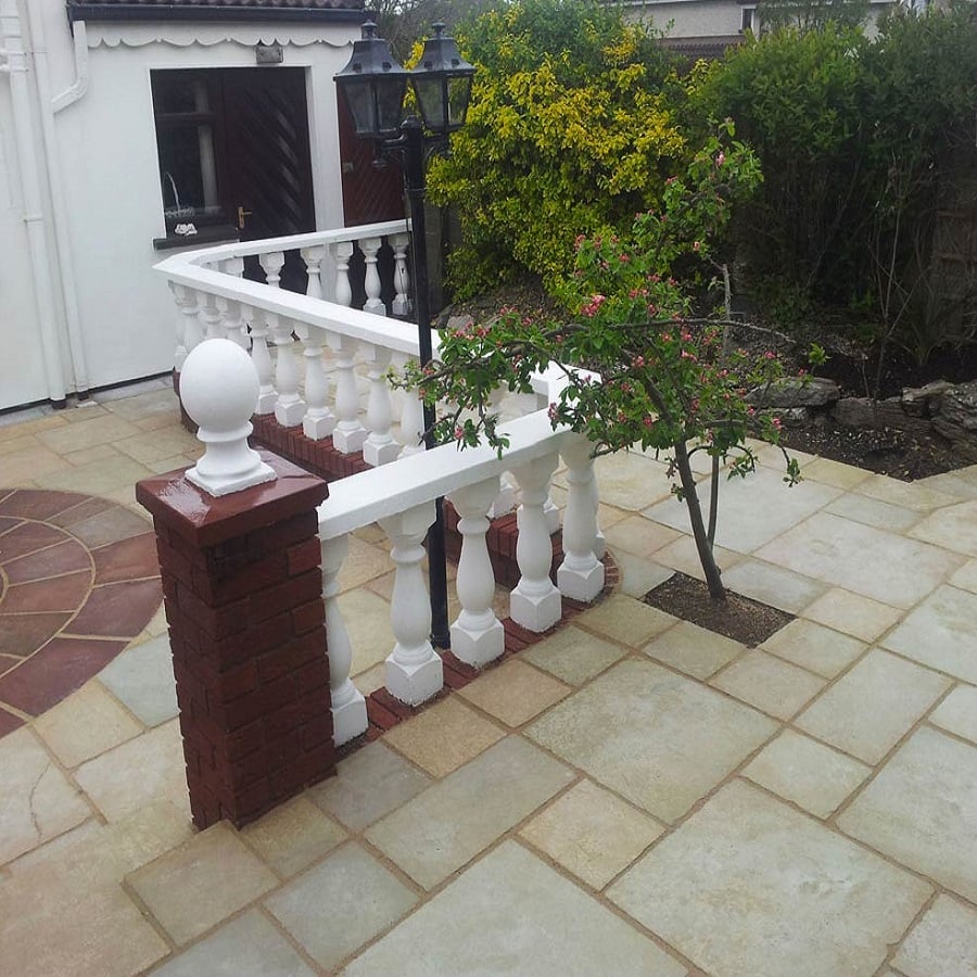 Elegant patio paved with sandstone and decorative balustrade