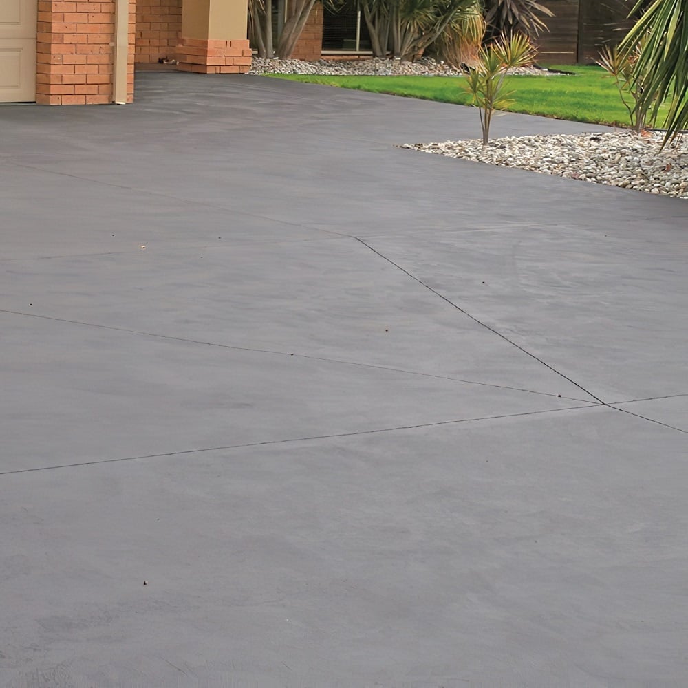 House front with clean concrete driveway and landscaped garden