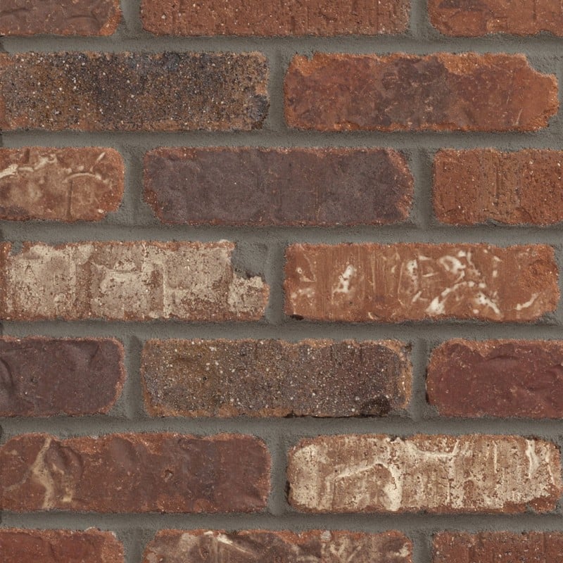 Close-up of rustic red and brown brickwork with dark grey mortar