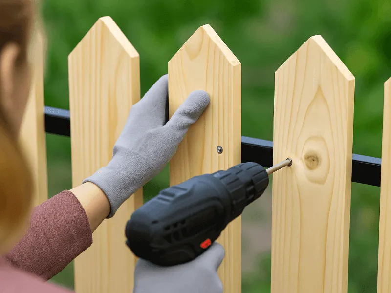 Securing a wooden fence with a power drill Fencing Equipment