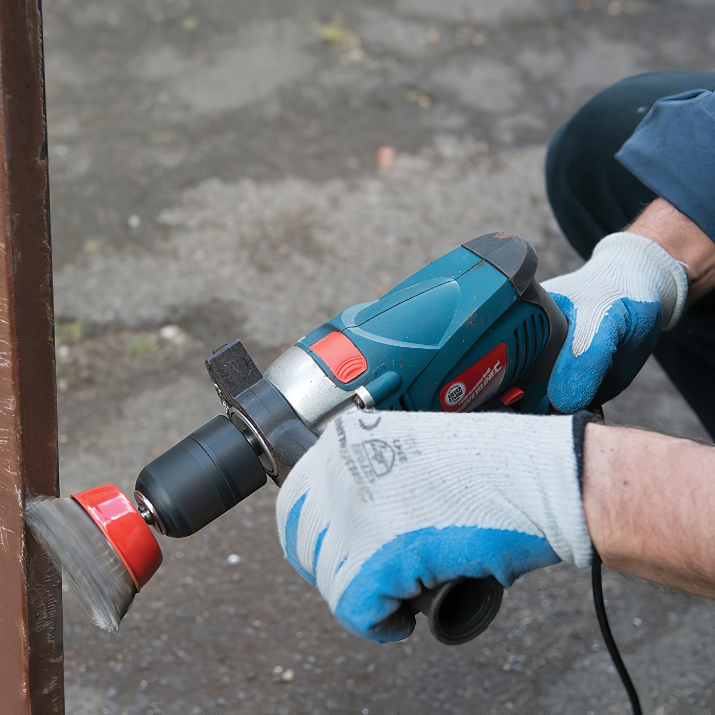 Pair of blue Silverline builders gloves using a drill wit a wire cup brush attachment