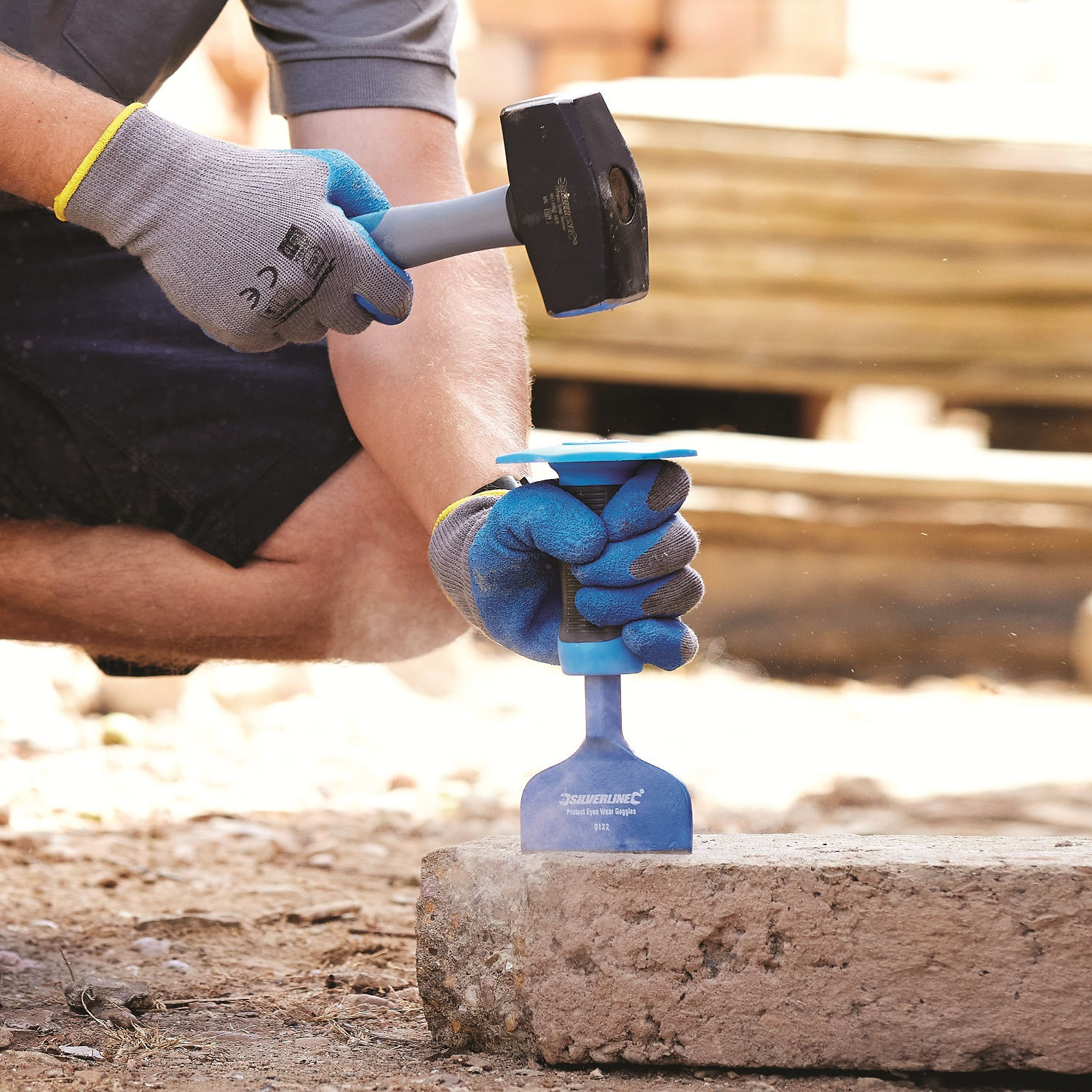 Pair of blue and grey builders gloves with abrasion resistant palms bricklayer cutting block