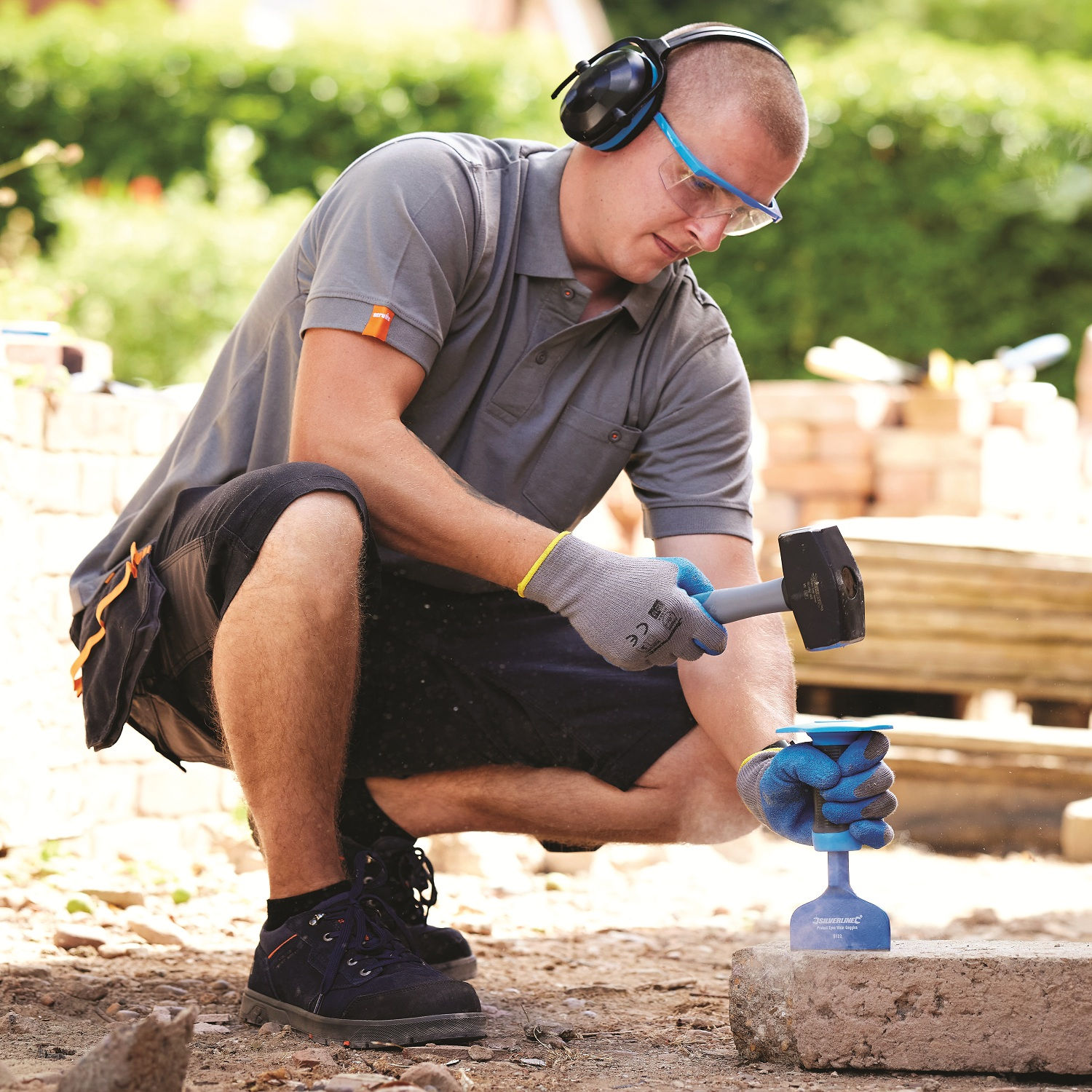 Pair of blue and grey builders gloves with abrasion resistant palms cutting block with a bolster