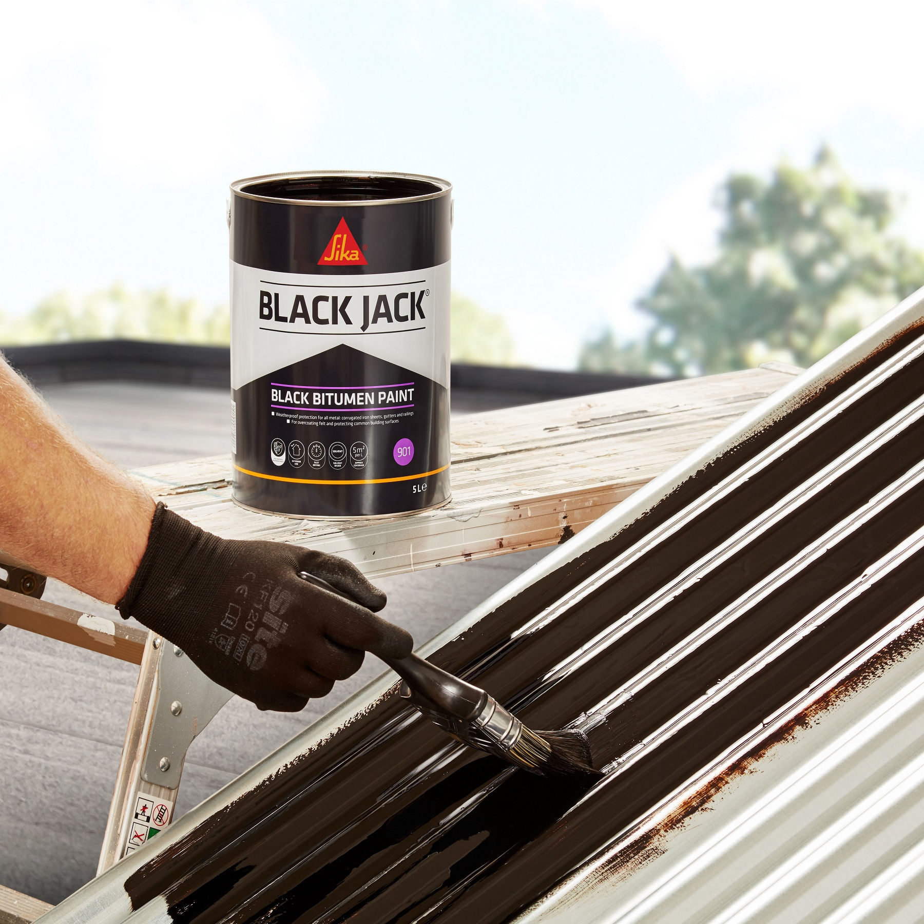 Sika 901 Black Jack Bitumen Paint being brushed onto corrugated metal roofing