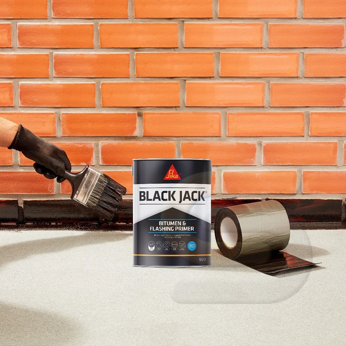 Sika Black Jack 902 Bitumen and Flashing Primer being applied beside flashing tape
