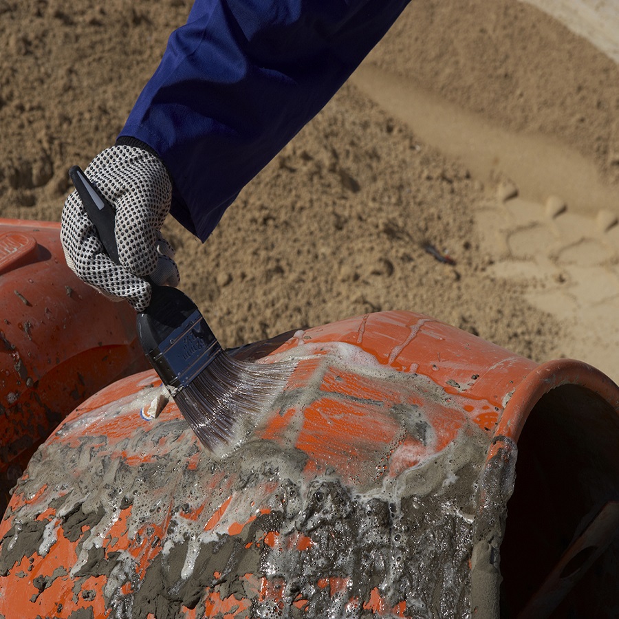 Applying cement cleaner to remove mortar and concrete residue from mixing equipment