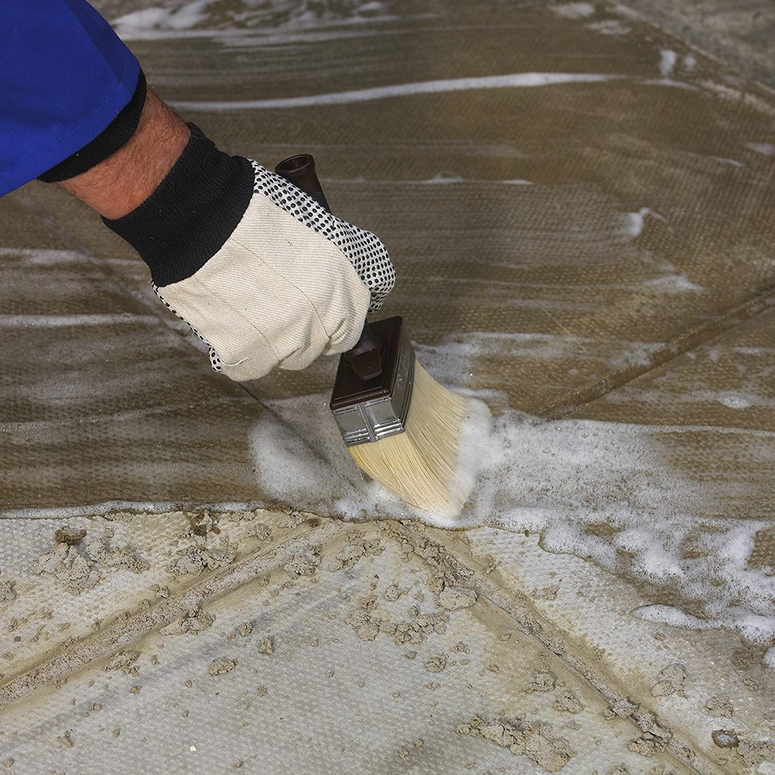 Applying cleaning solution to patio surface to remove cement and mortar residue