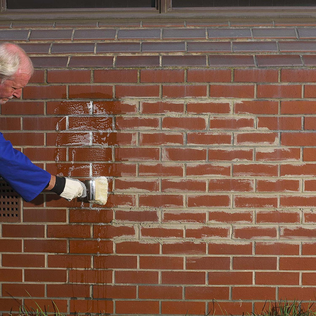 Applying cleaning solution to brickwork to remove mortar and cement residue