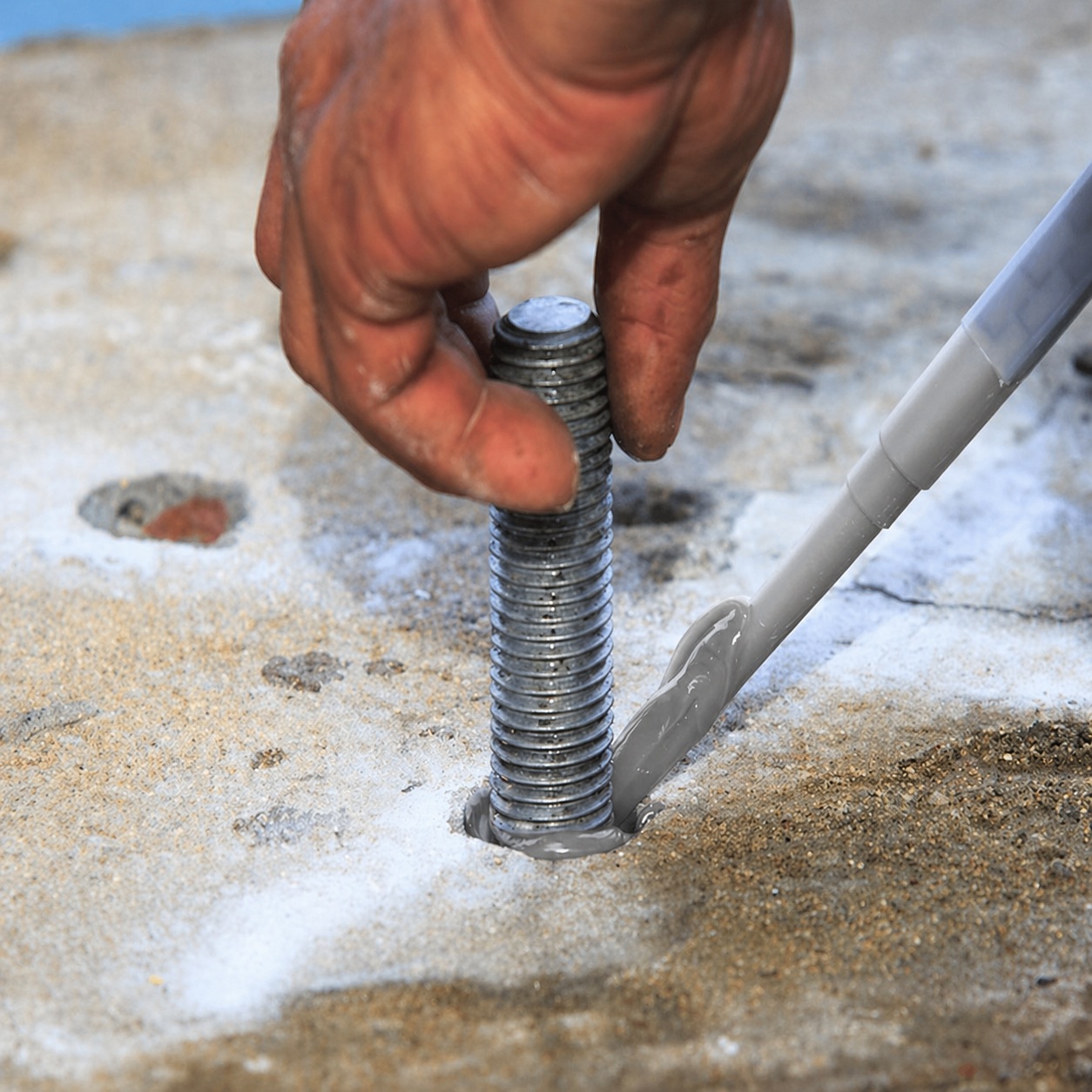 Sika Everbuild Anchorset chemical anchor resin being applied around threaded rod in concrete