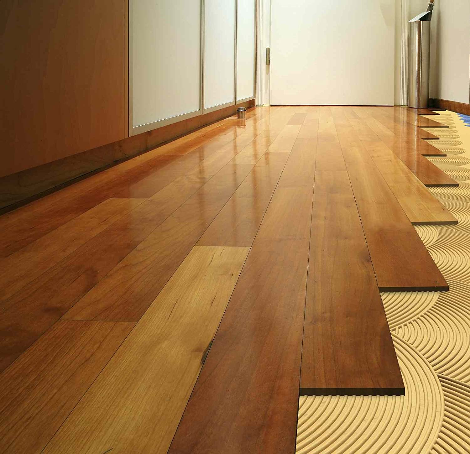 Finished wooden flooring installed over adhesive with underfloor heating system