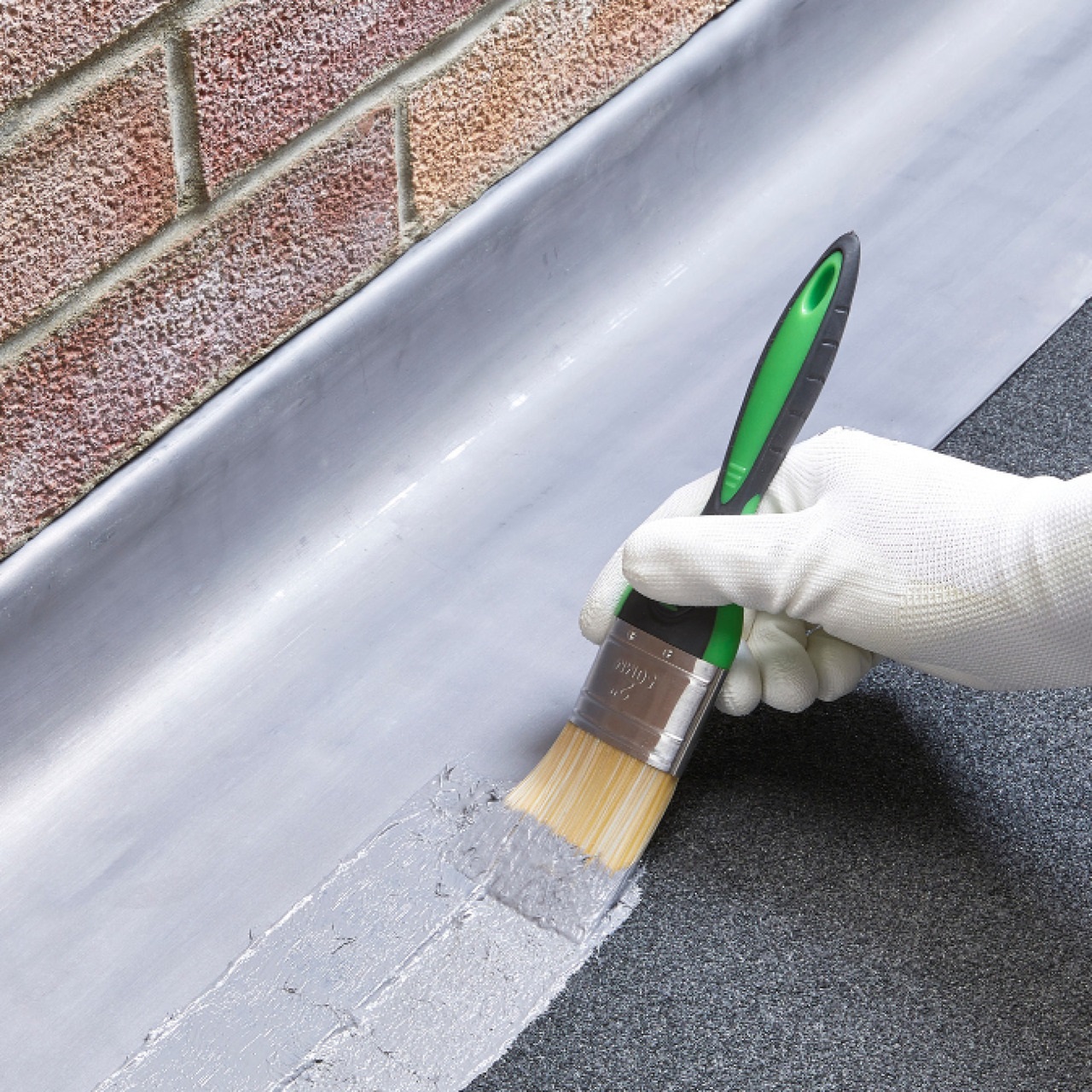 Sika Evercryl grey roof repair compound being applied to metal roof flashing