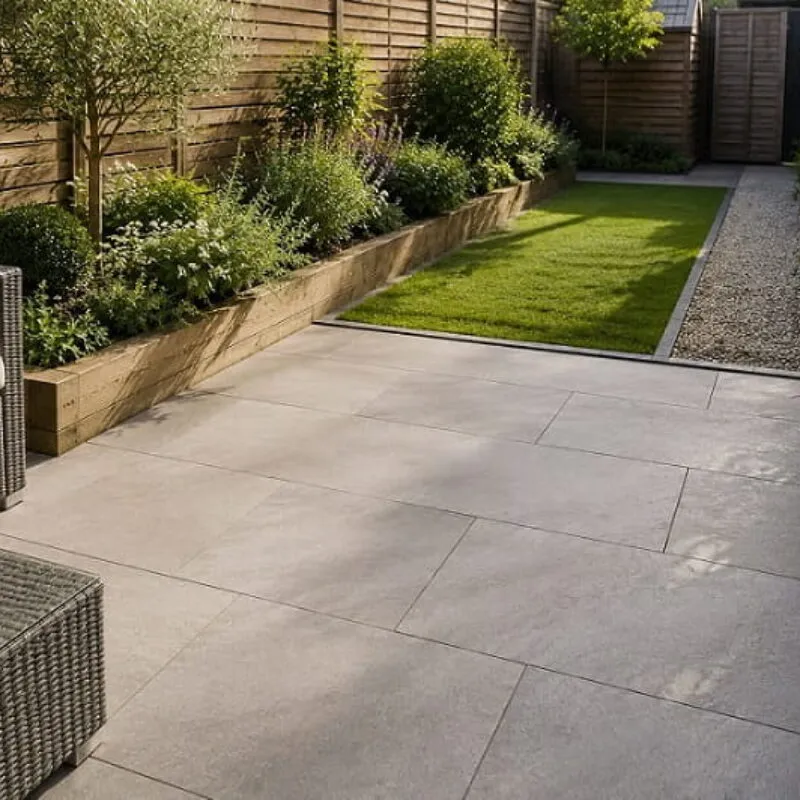Low Maintenance Small Garden Path and Patio Design Low-maintenance small UK garden featuring a large-format paved patio, straight gravel path, raised planting beds and neatly edged lawn designed for easier upkeep.
