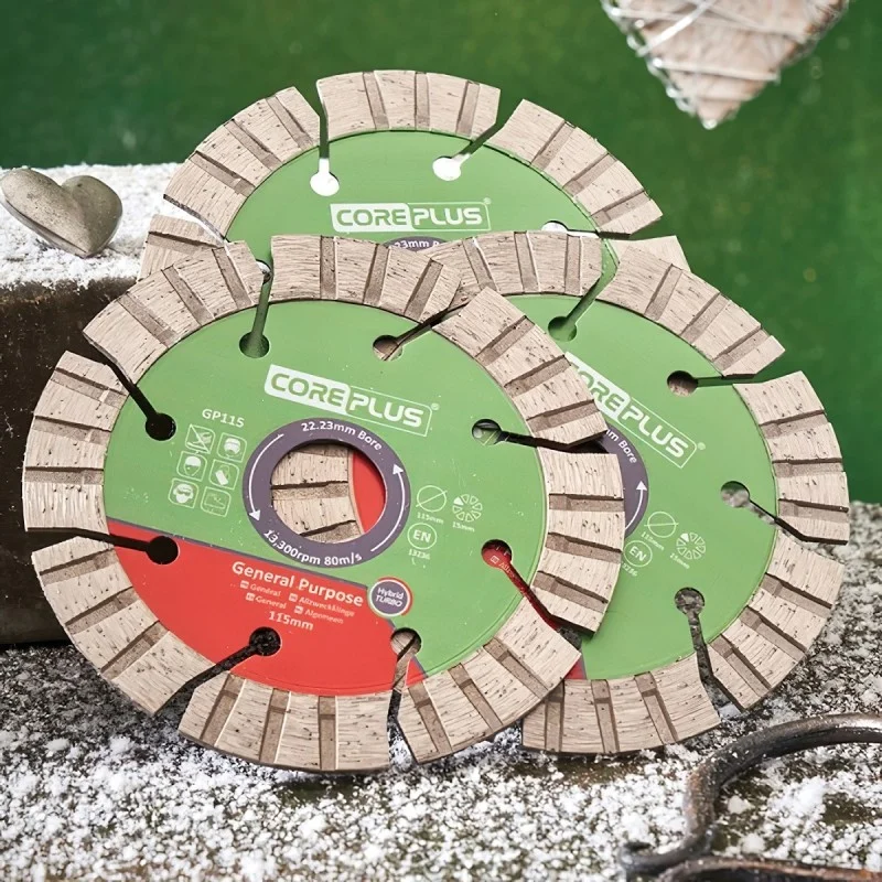 Coreplus diamond cutting blades overlapping on a dusty work surface.