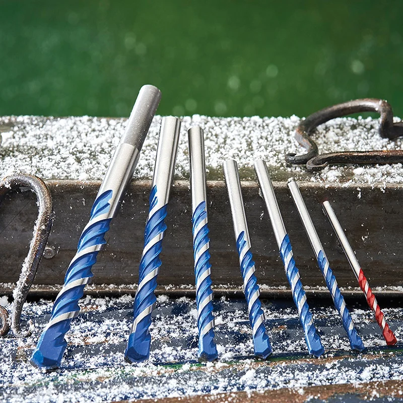 Faithfull multi-material drill bits arranged on a textured surface in an outdoor display.
