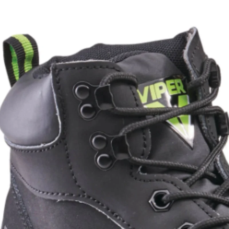 Close-up of a black work boot showing the laces, metal eyelets, padded collar and green pull tab.