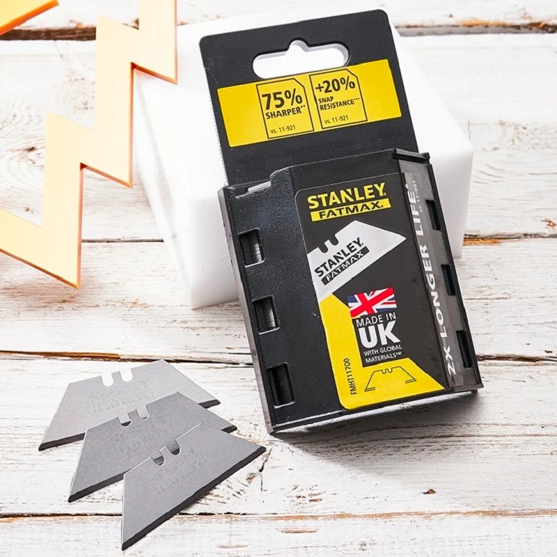Stanley FatMax blade dispenser and loose utility blades displayed on a pale wooden work surface.