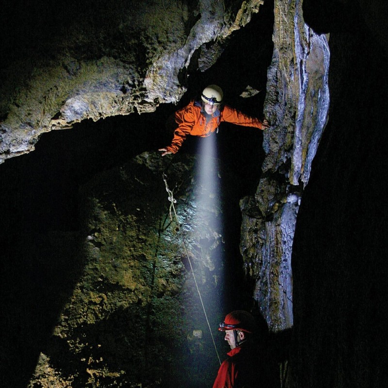 LED Lenser H3.2 head torch providing hands-free lighting during rock climbing in a dark rocky setting