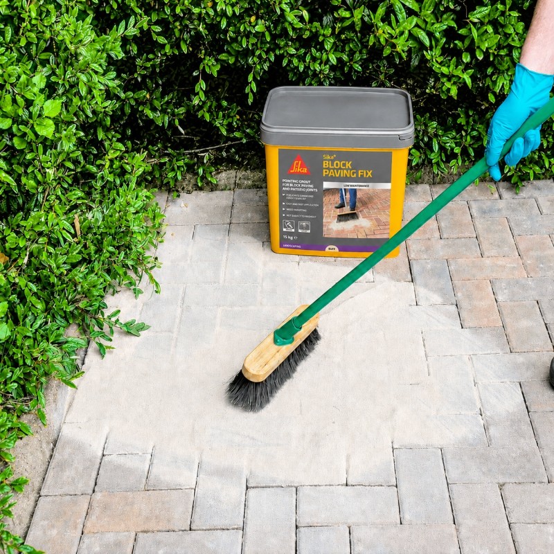 Sika Block Paving Fix Buff 15kg being swept across block paving during application